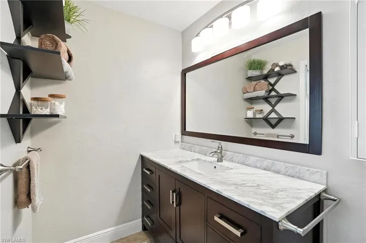 Kitchen featuring white appliances, ceiling fan, lofted ceiling, light tile patterned floors, and white cabinetry