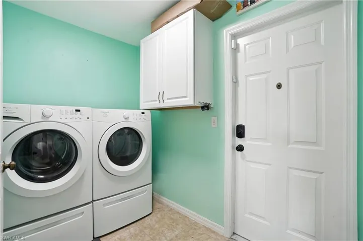 Tiled living room with ceiling fan, vaulted ceiling, and washer / dryer