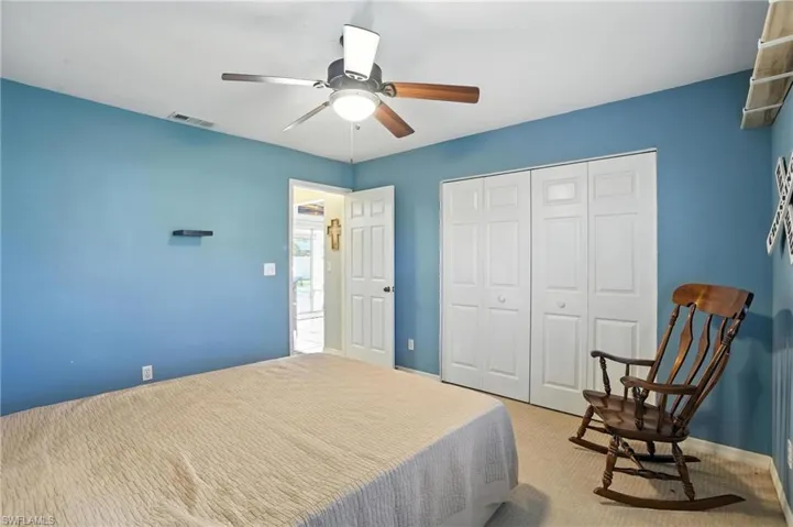 Carpeted bedroom with a closet and ceiling fan