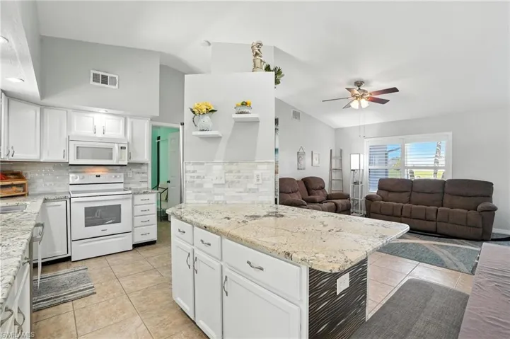Bedroom featuring a closet, a ceiling fan, light tile patterned floors, and ensuite bath