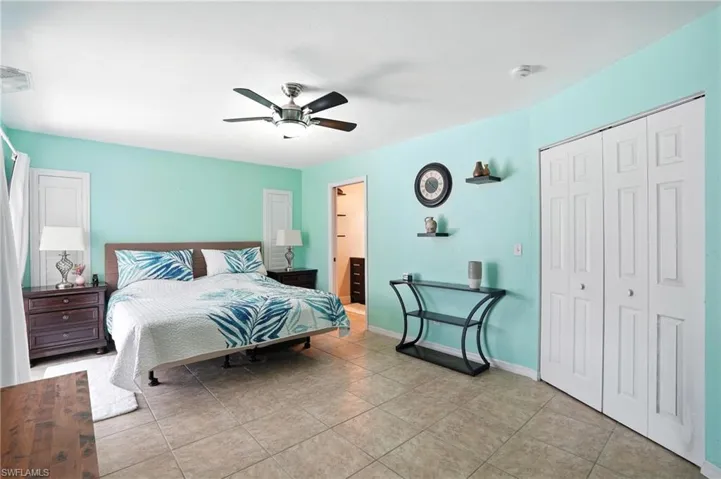 Living room with vaulted ceiling, tile patterned flooring, a ceiling fan, and a premium fireplace