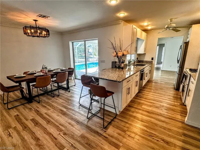 Kitchen with ornamental molding, a sink, light wood-style floors, visible vents, and appliances with stainless steel finishes