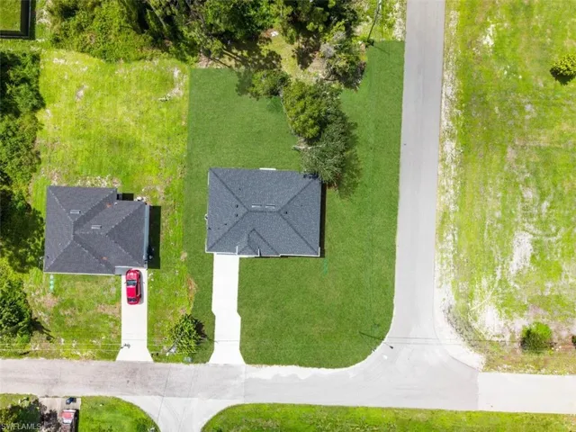 Detached single-story property featuring a dark-toned roof and a light-colored driveway