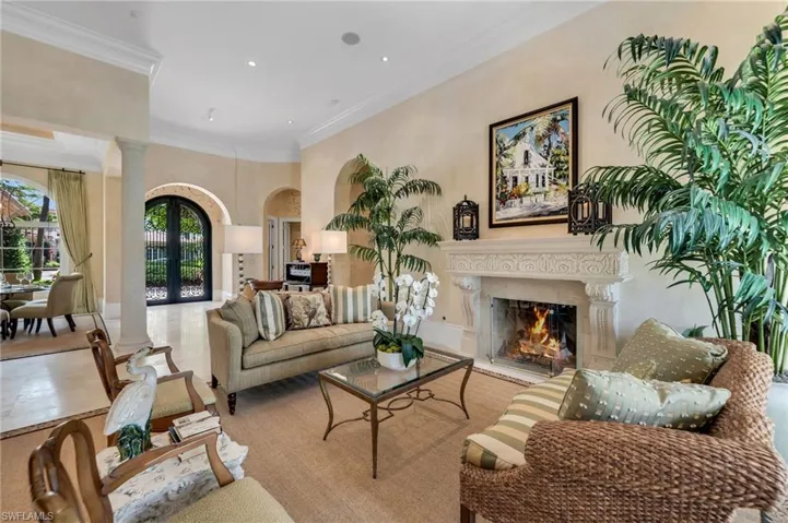 Beautiful entry leads to formal living room with stone fireplace, travertine floors, and high ceilings.