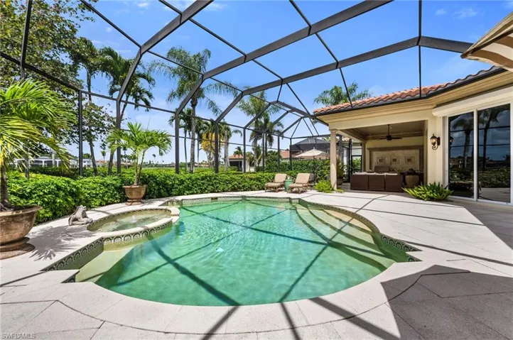 Expansive pool/spa and outdoor entertaining area with views of lake and golf course beyond.