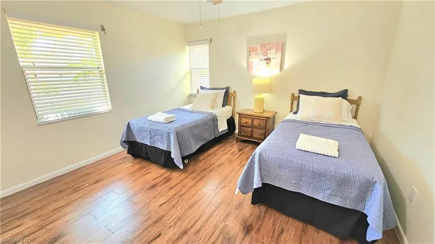 Bedroom featuring multiple windows and wood-type flooring