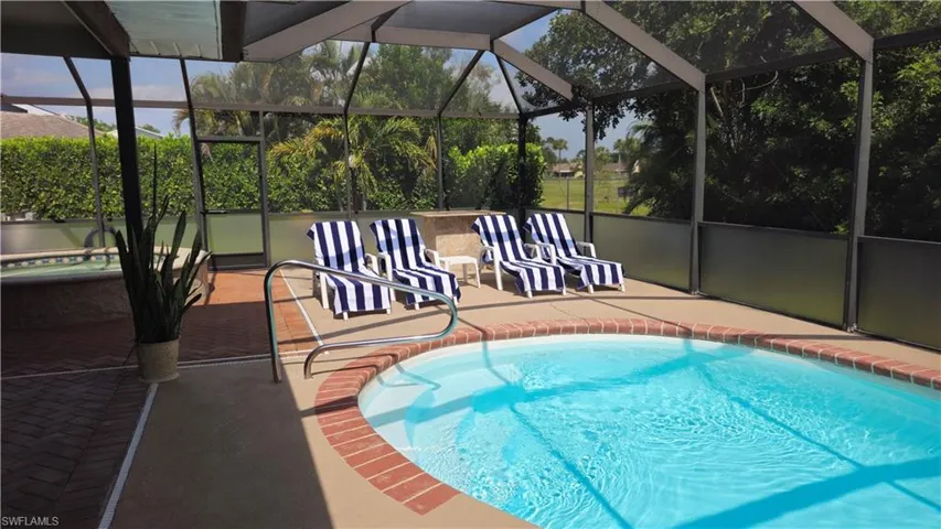View of pool with a patio and glass enclosure