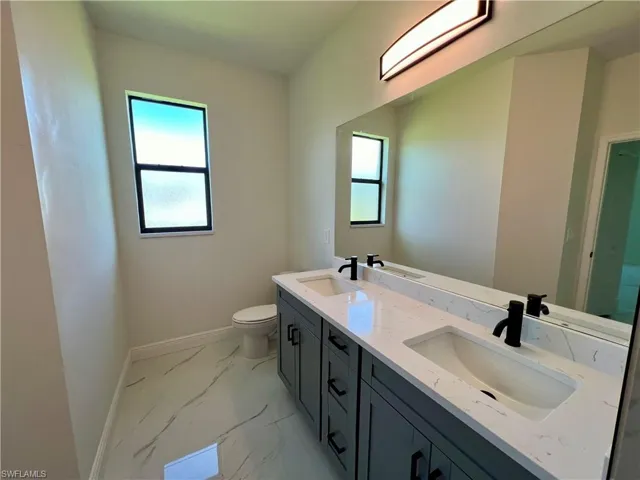 Primary bathroom with dual sinks vanity and toilet