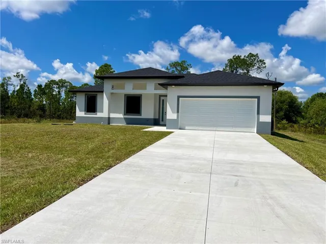 View of front facade featuring a front lawn and a garage