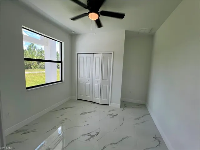Den featuring ceiling fan and a closet