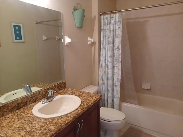 Full bathroom with shower / bath combo and vanity