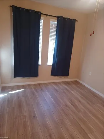 Spare room with light wood-style flooring and baseboards