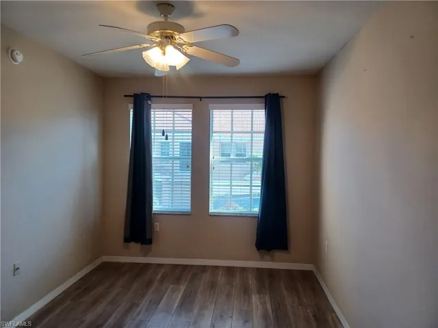 Spare room featuring dark wood-style flooring and ceiling fan