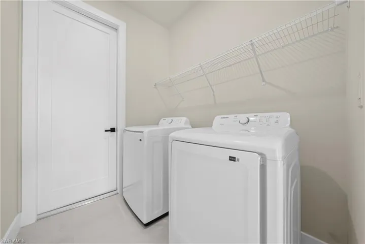 Laundry room featuring separate washer and dryer and baseboards