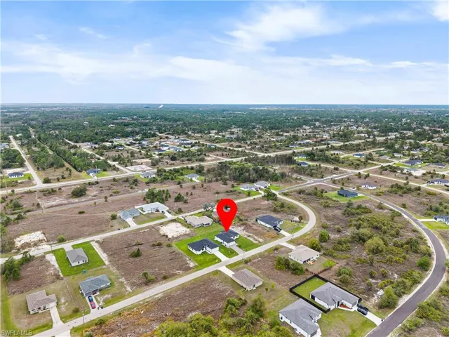 Aerial view of property and surrounding area featuring nearby suburban area