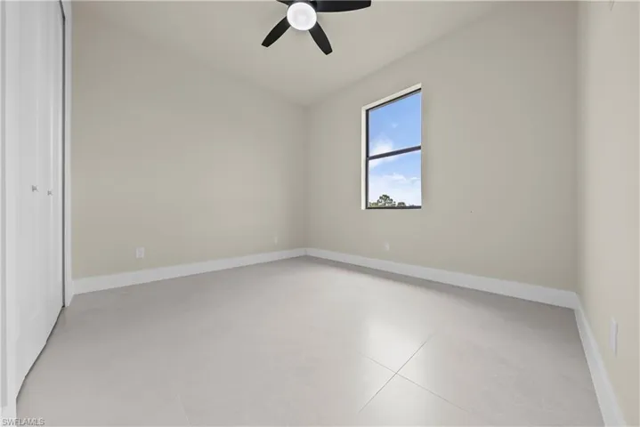Unfurnished bedroom with ceiling fan and a closet