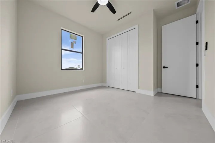Unfurnished bedroom with a closet, ceiling fan, and concrete floors