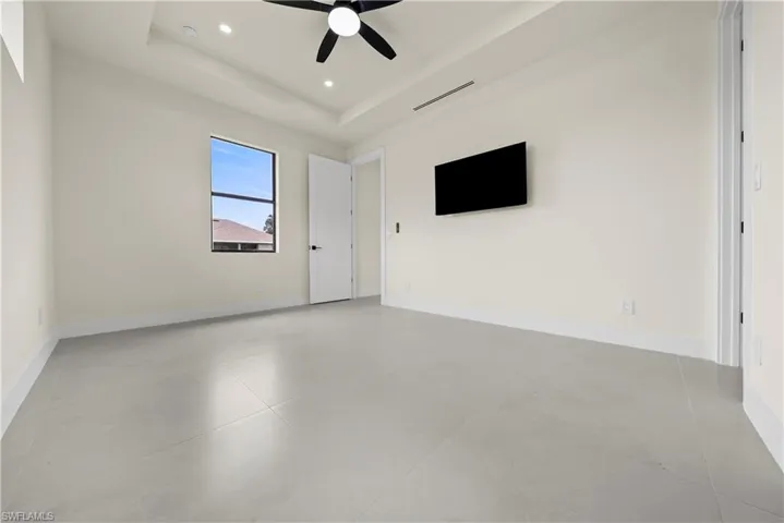 Unfurnished room with ceiling fan, recessed lighting, a raised ceiling, and concrete floors