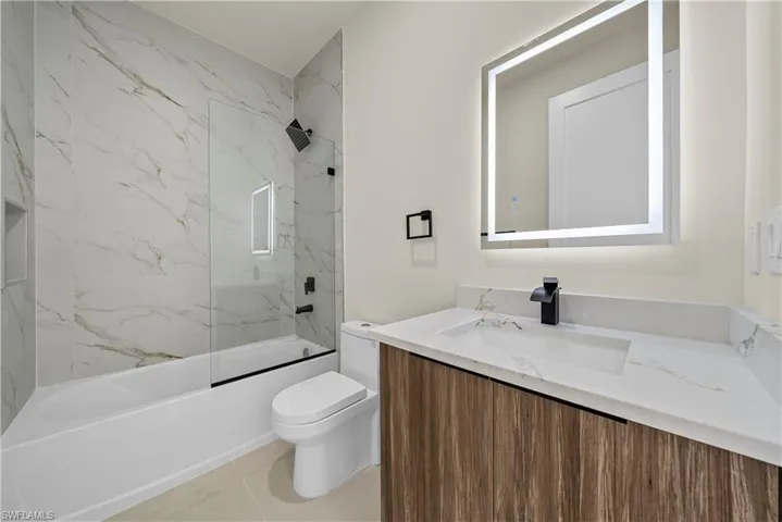 Bathroom featuring vanity and washtub / shower combination
