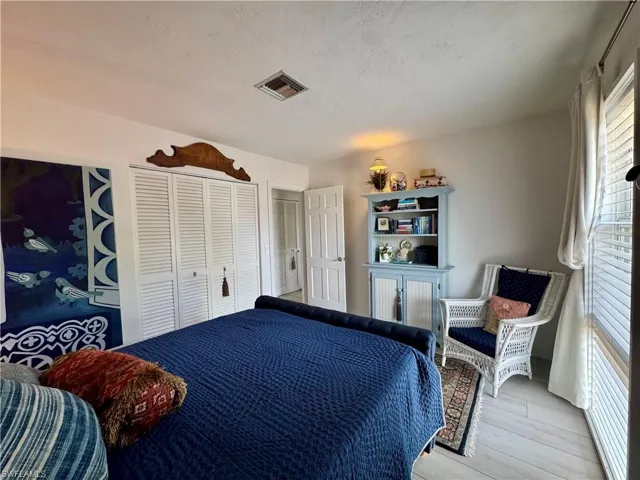 Bedroom featuring a closet, a textured ceiling, and wood finished floors