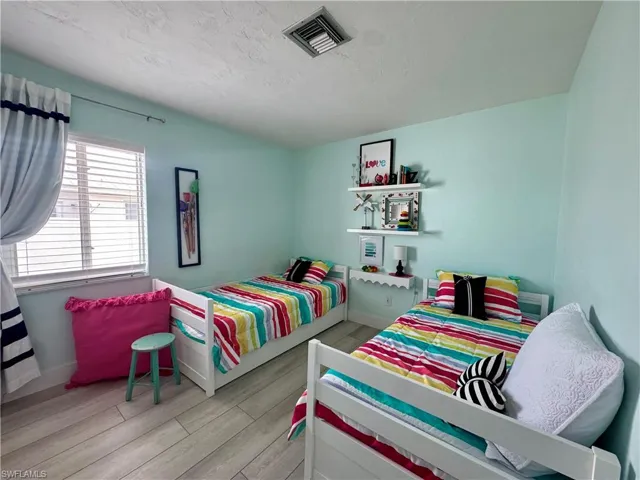 Bedroom featuring light wood finished floors and a textured ceiling