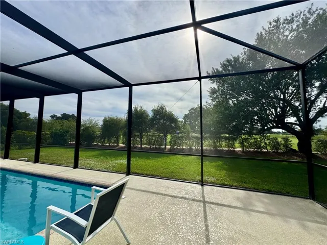 Outdoor pool with a lanai, a lawn, and a sunroom