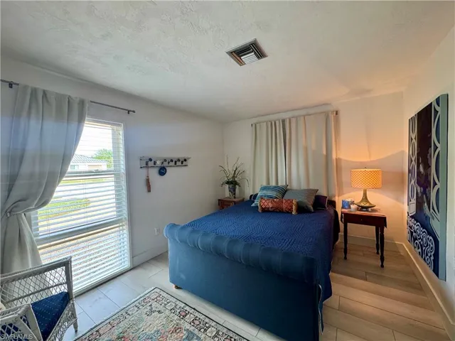 Bedroom with a textured ceiling and light wood-style floors