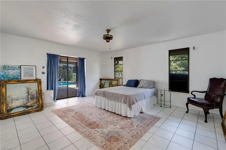 Bedroom featuring access to exterior, a ceiling fan, and light tile patterned flooring