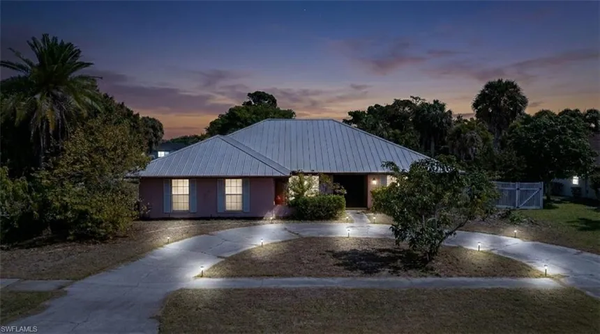 Single story home with a metal roof and curved driveway