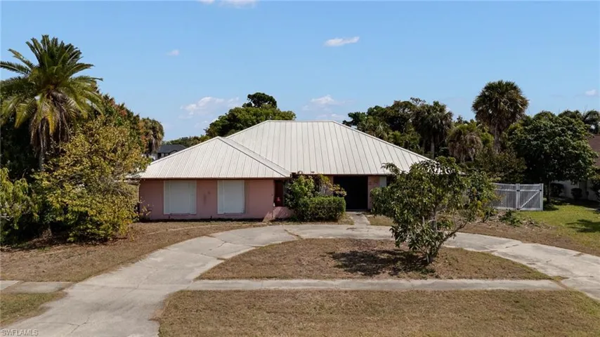 Ranch-style house with a metal roof and curved driveway