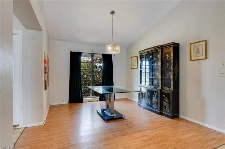 Dining area with lofted ceiling and light wood-style floors
