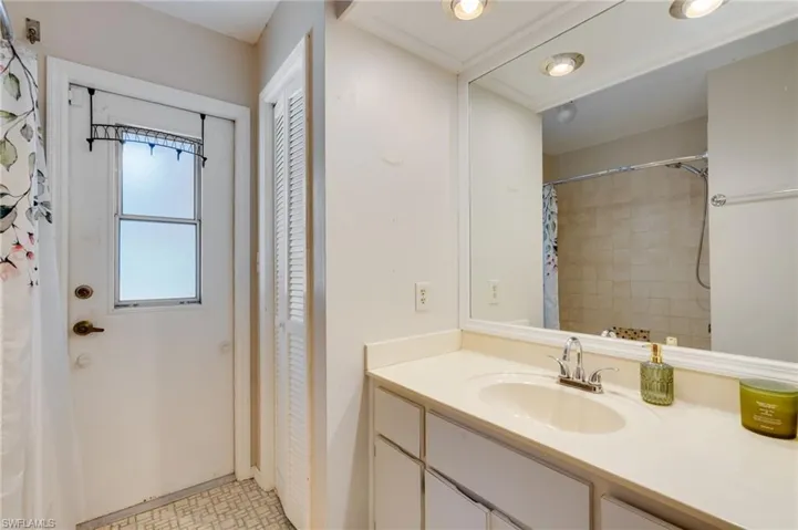 Full bath with a closet, vanity, a shower with curtain, and light floors