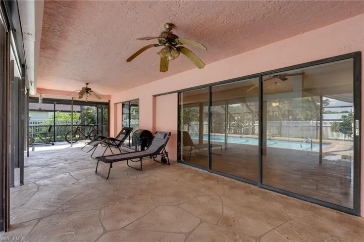 Sunroom with a ceiling fan and a patio