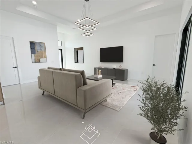 Tiled living room with a tray ceiling and a chandelier