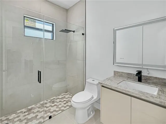 Bathroom with vanity, a stall shower, and light tile patterned floors
