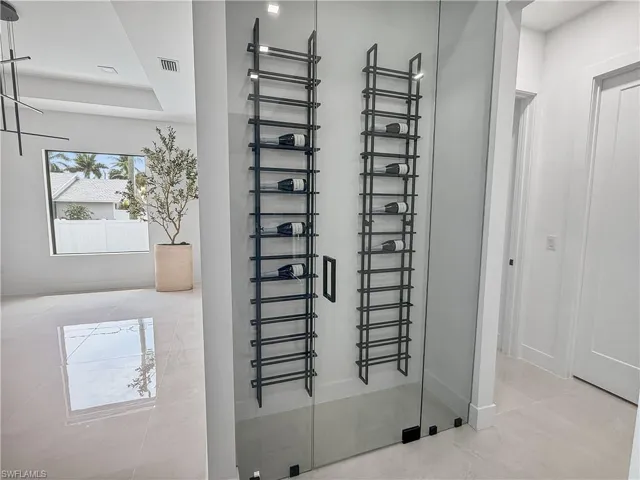 Glass-enclosed wine display featuring matte black vertical racks