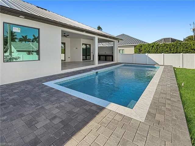 View of swimming pool featuring a patio area, ceiling fan, and a fenced backyard