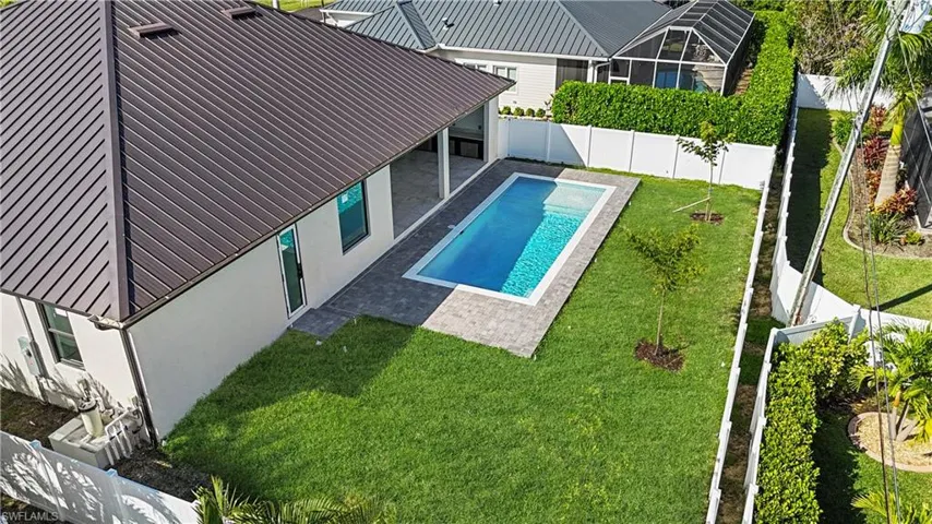 View of pool with a patio area, a fenced backyard, and a lanai