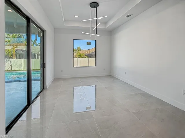 Unfurnished dining area with a raised ceiling and a chandelier