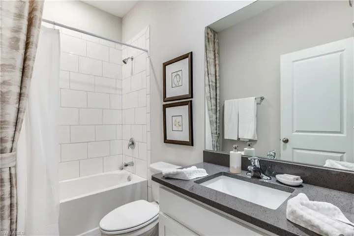 Full bathroom featuring shower / bath combo with shower curtain, toilet, and vanity