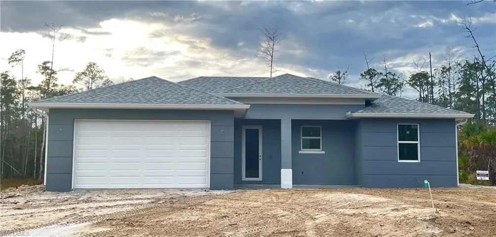 View of front facade featuring roof with shingles, a garage, stucco siding, covered porch, and driveway