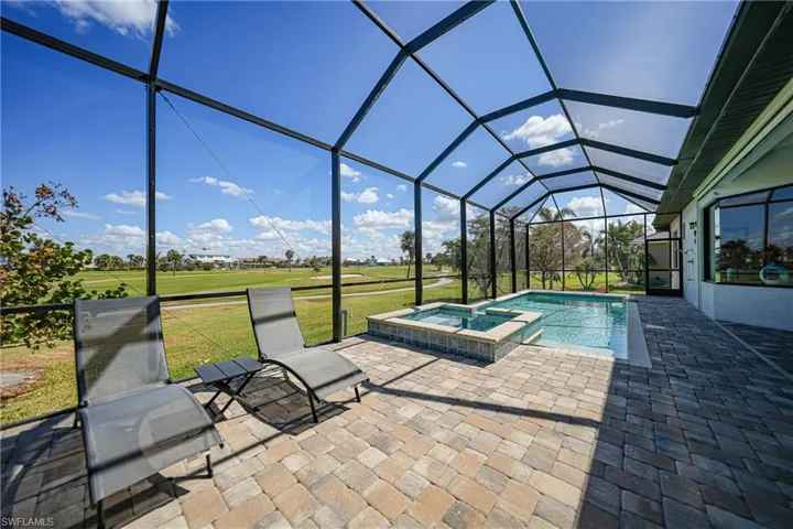 View of swimming pool featuring an in ground hot tub, a patio area, a lanai, and a lawn