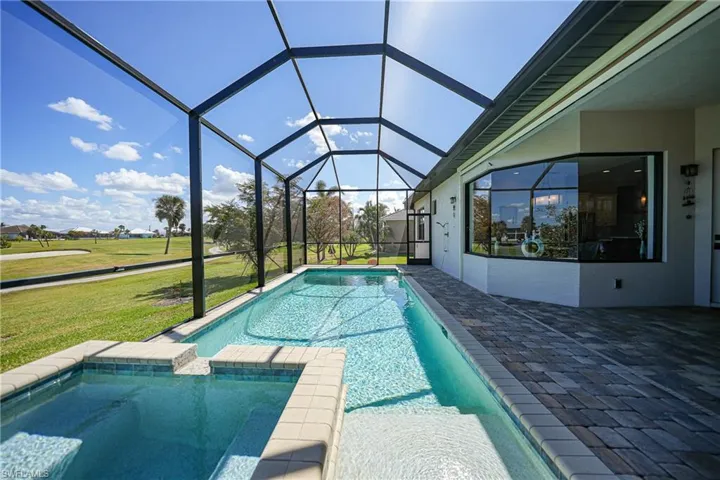 View of swimming pool featuring a patio, a lanai, and a lawn