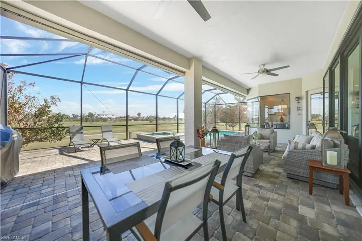 View of patio / terrace with an in ground hot tub, ceiling fan, glass enclosure, and an outdoor hangout area