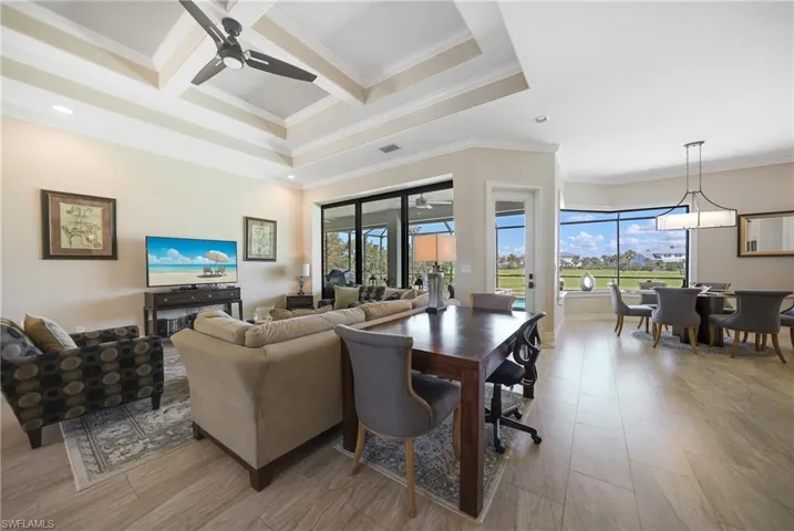 Living room with beam ceiling, ornamental molding, coffered ceiling, and ceiling fan