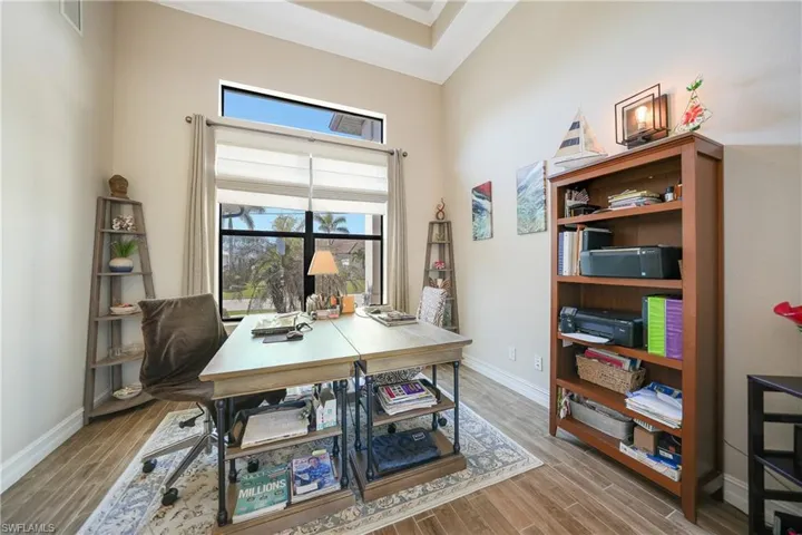 Office area with crown molding and light wood-type flooring