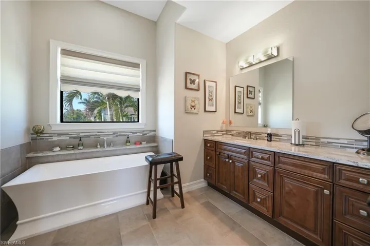 Bathroom with vanity, a tub, and tile patterned floors