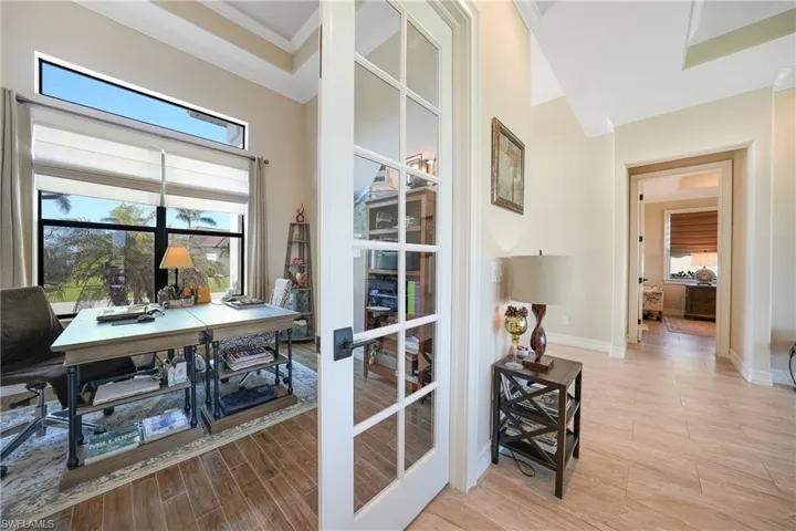 Entryway featuring crown molding, a high ceiling, french doors, and light wood-type flooring
