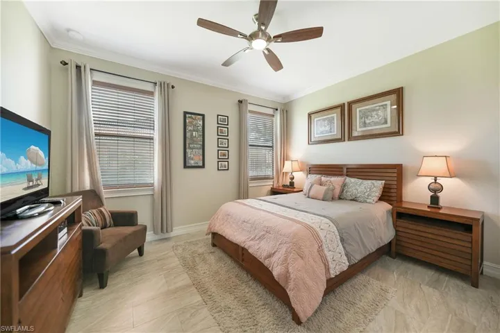 Bedroom with ceiling fan and ornamental molding
