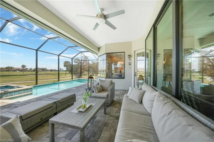 View of patio with a swimming pool with hot tub, an outdoor living space, glass enclosure, and ceiling fan